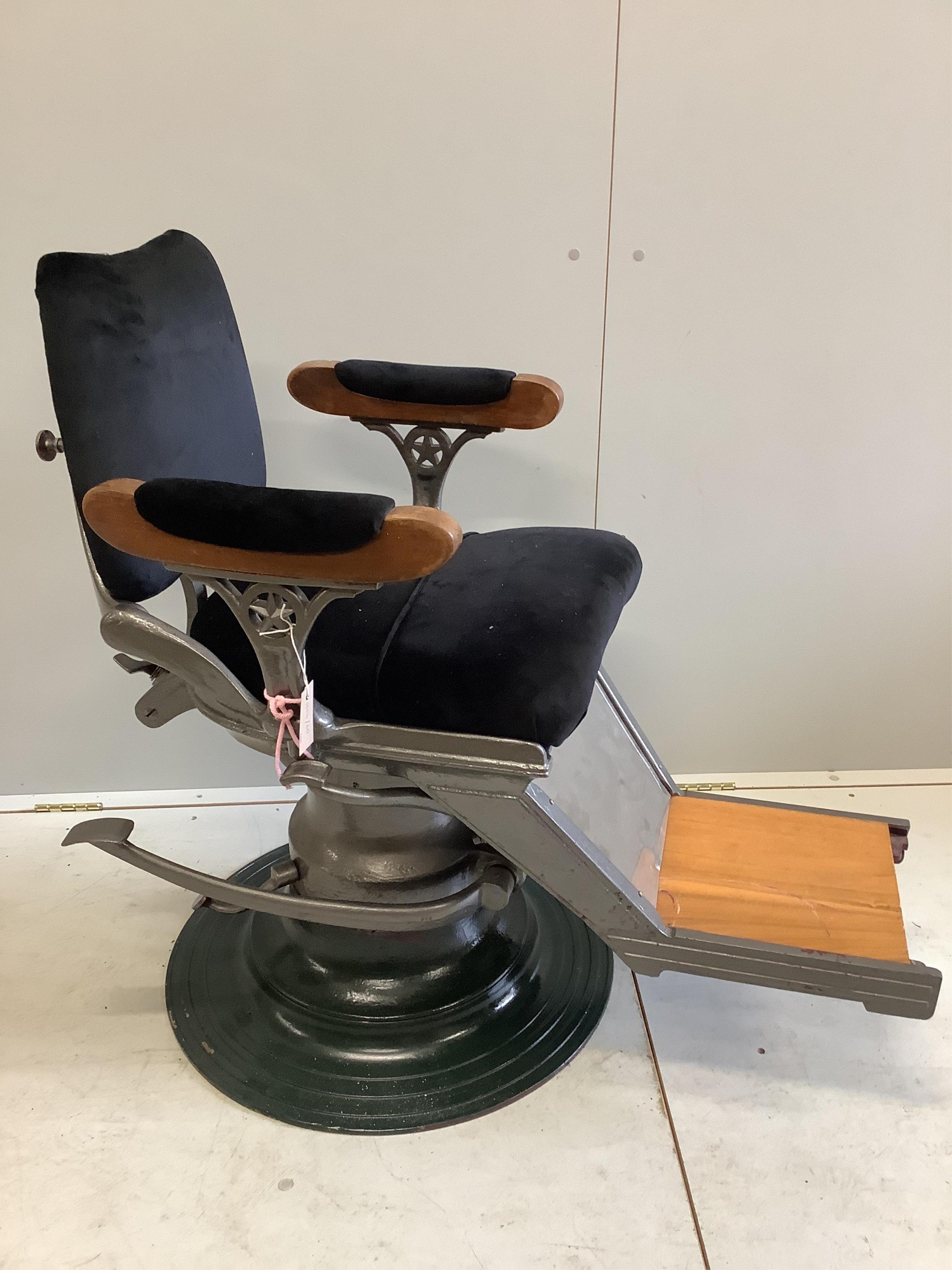 A pair of heavy cast iron upholstered and teak barber's chairs. Condition - fair to good, one with loose arms